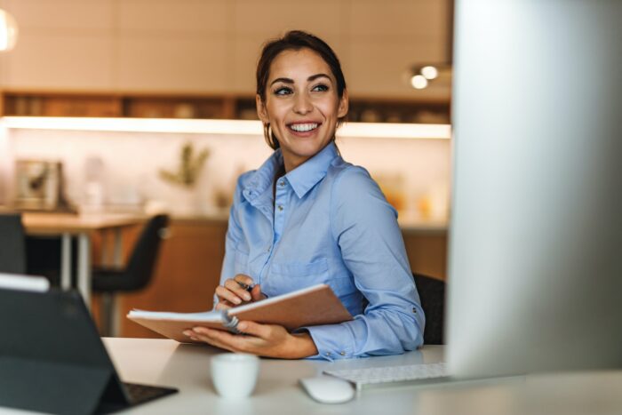 Smiling at monitor, looking happy.