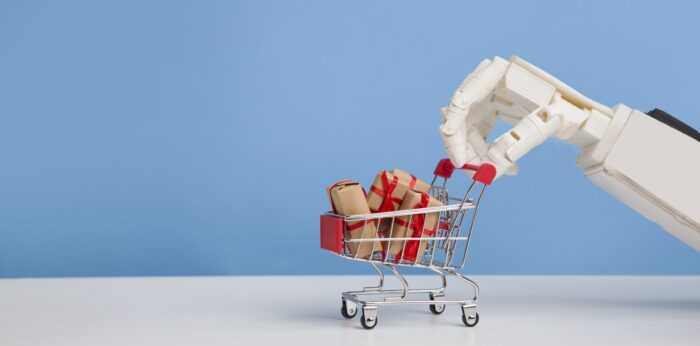 Robot hand with shopping cart full of gift boxes, blue background