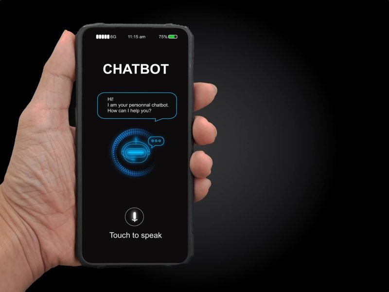 A man's hand holding mobile smartphone with chatterbot application